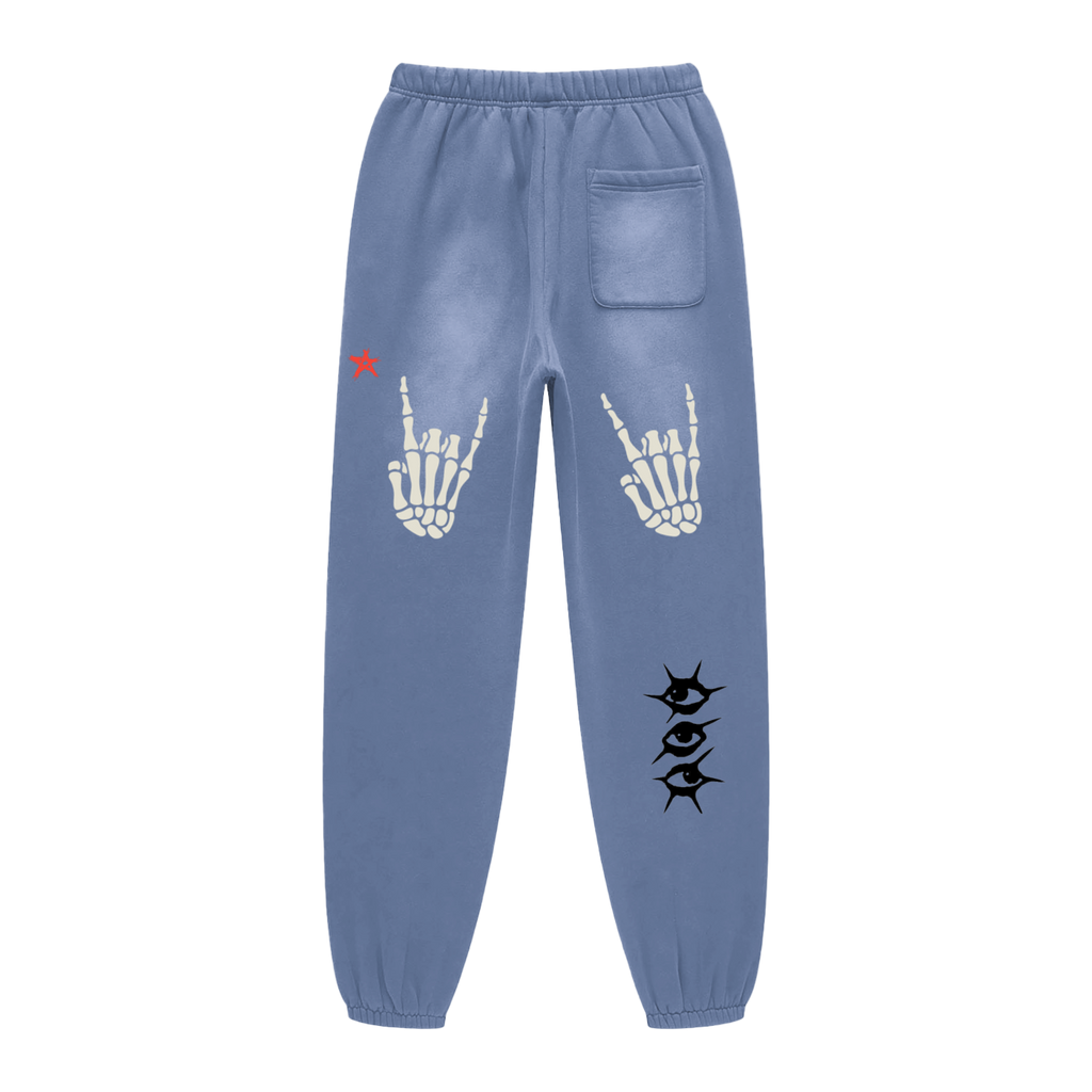 Blue sweatpants with skeleton hand and eye designs on a white background
