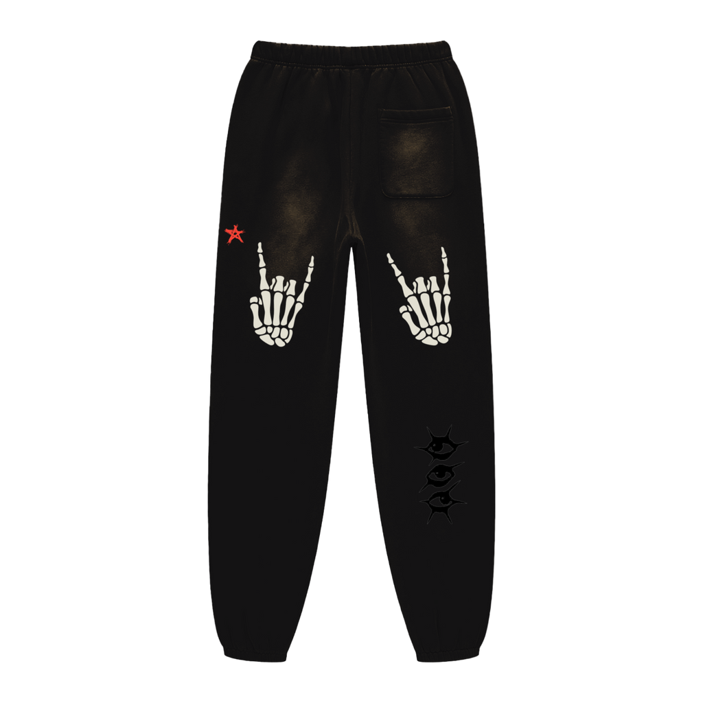 Black sweatpants with skeleton hand and star designs on a white background